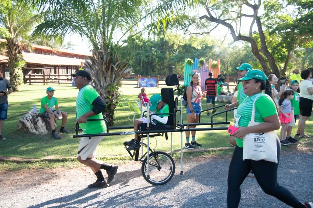 Pais e filho correm juntos pela primeira vez com cadeira adaptada para trilha no Circuito Sesc de Corrida – etapa Pantanal